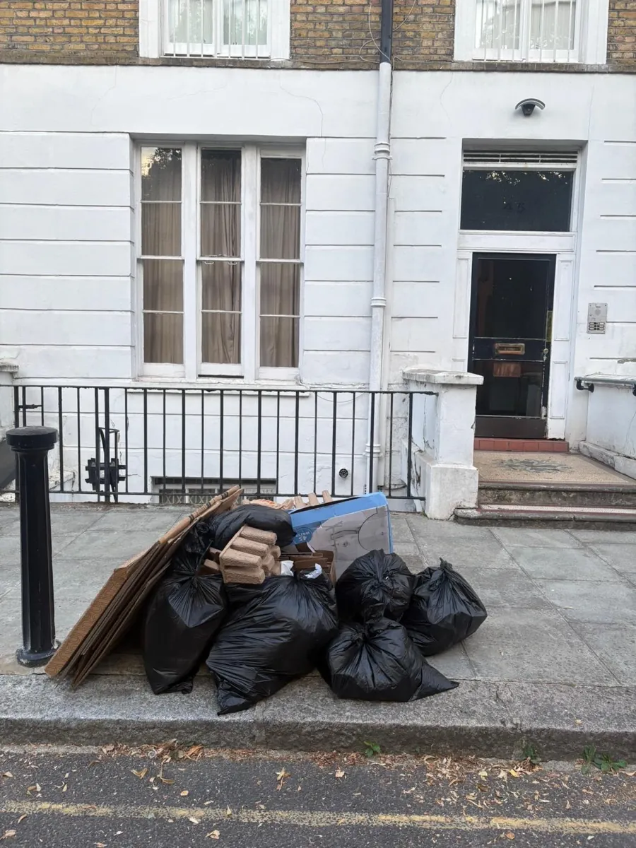 Before rubbish removal in Harlesden NW10 — black refuse sacks, flattened cardboard and moulded packaging piled on the pavement outside a terraced property