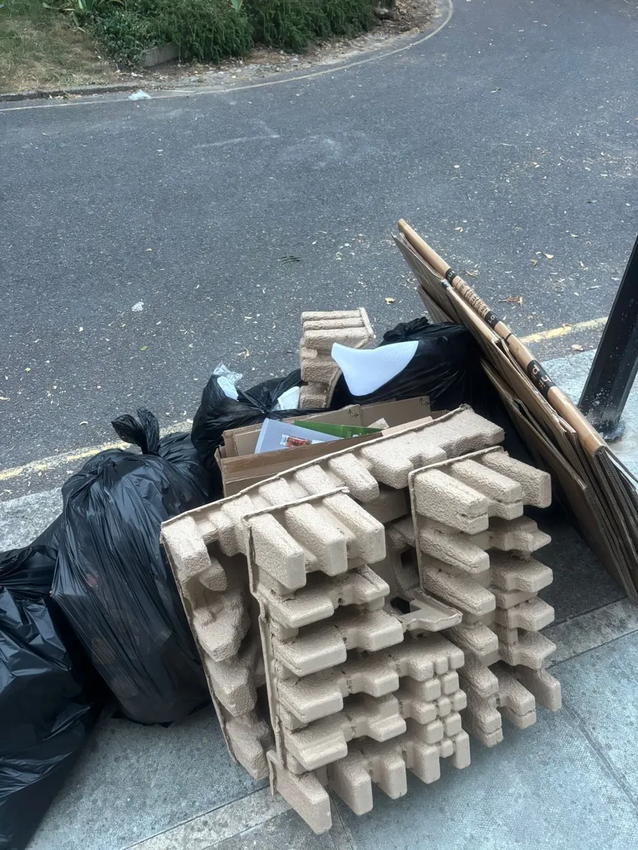 Close up of cardboard and moulded pulp packaging waste awaiting collection at the kerbside in Harlesden NW10